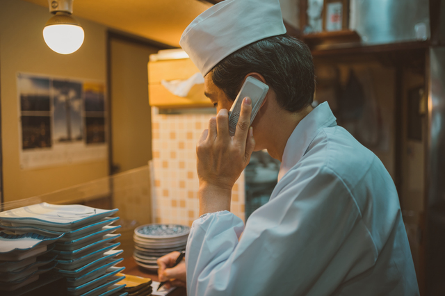 電話に出ている店主